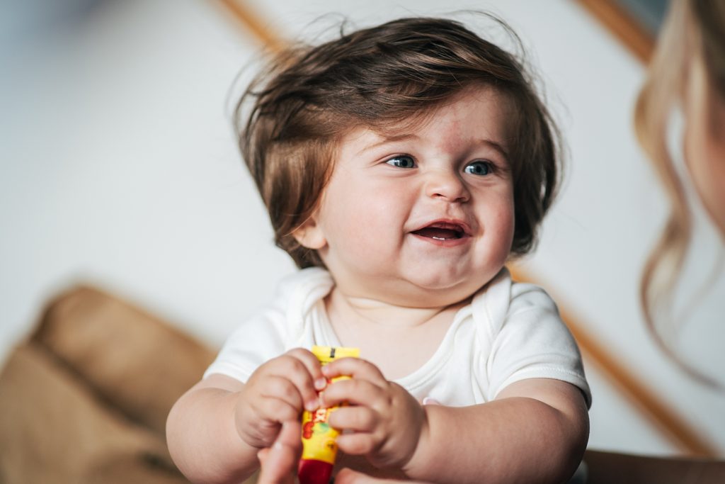 baby with a lot of hair laughs