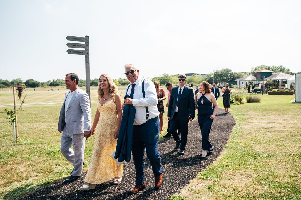 wedding guests make their way from a marquee to the ceremony