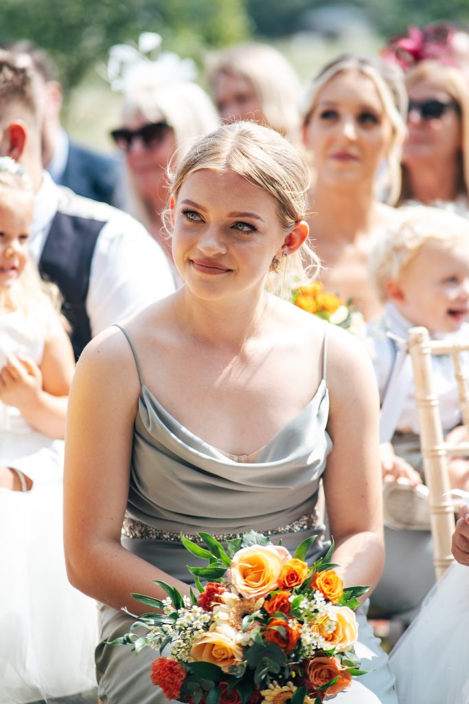 bridesmaid looks emotional as she watches parents get married
