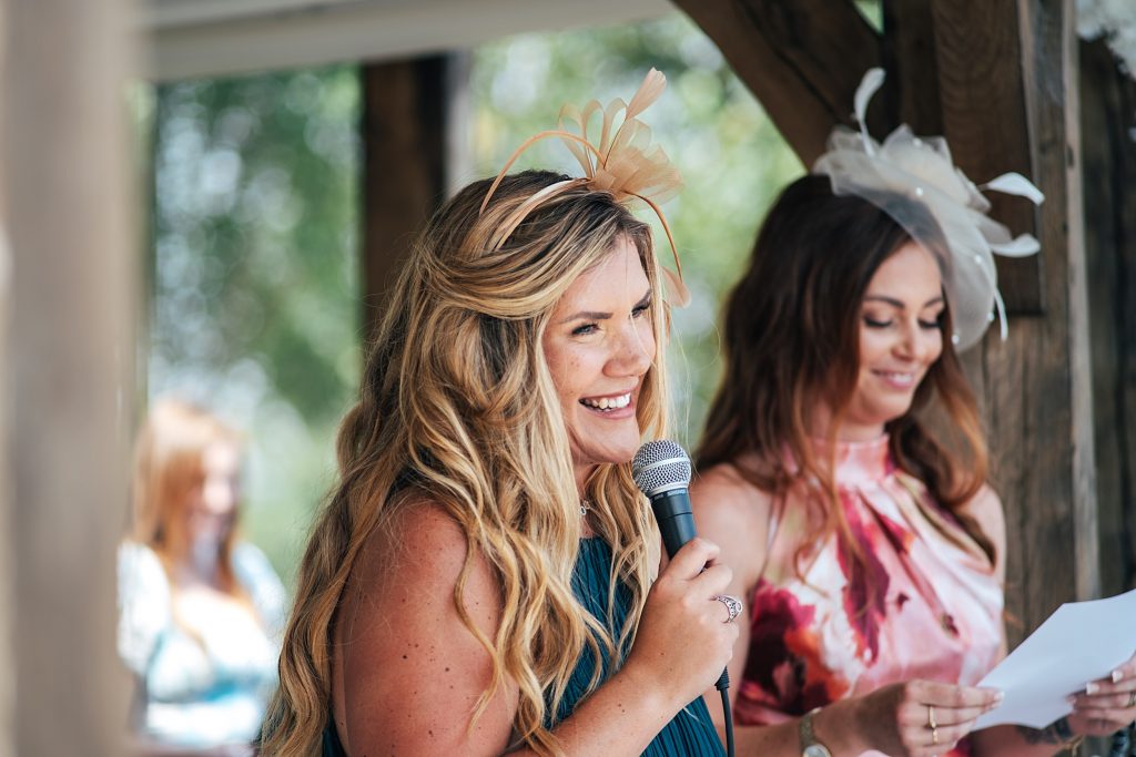 smiling guest gives reading at ceremony