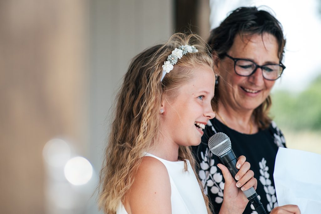 flower girl smiles and gives reading during ceremony