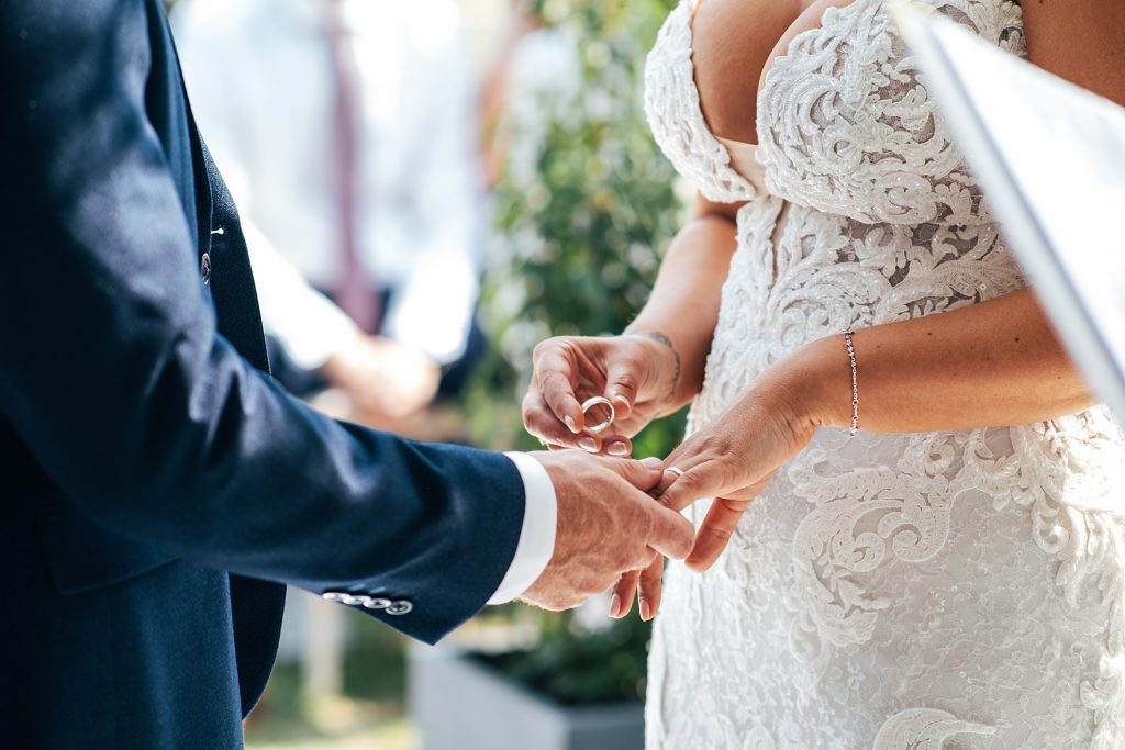 bride puts ring on grooms finger