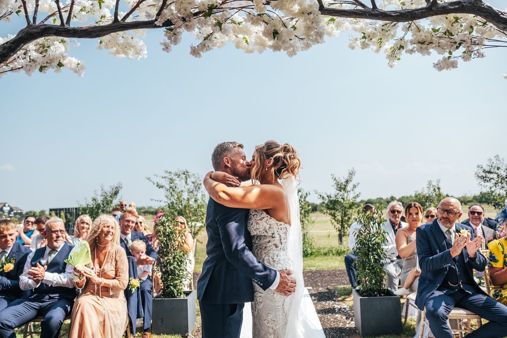 bride and groom kiss at end of wedding ceremony
