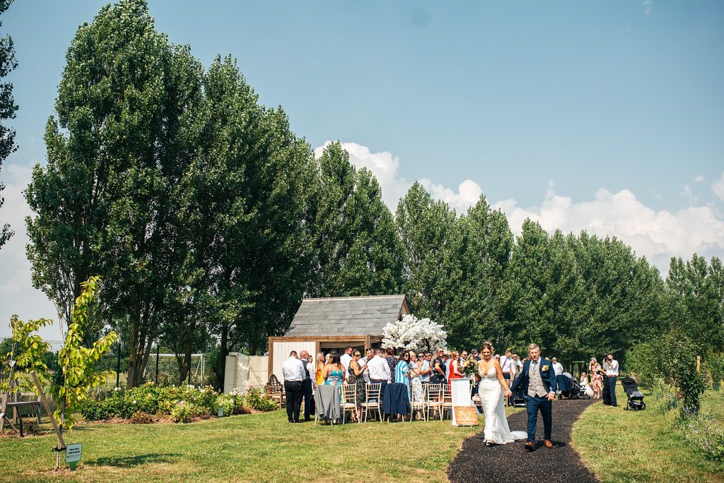 wide view of bride and groom walking away from outdoor ceremony