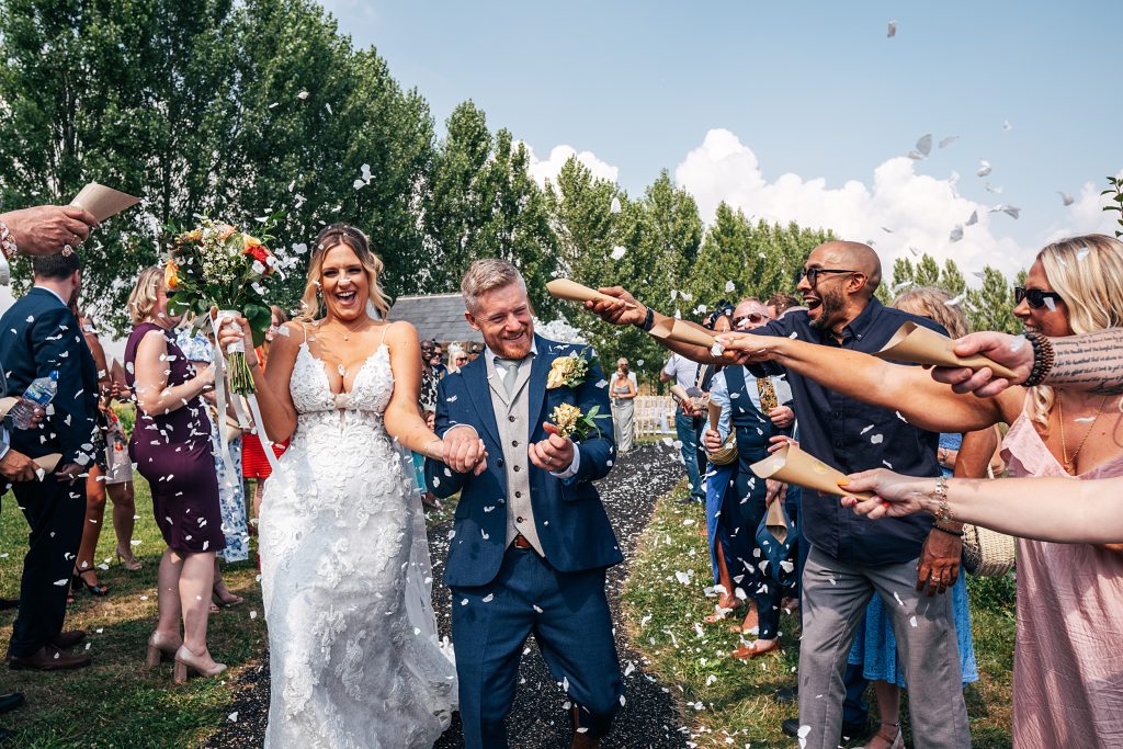bride and groom walk confetti tunnel