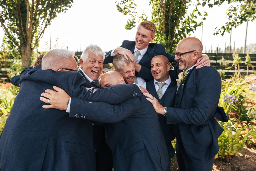 groomsmen jump on groom