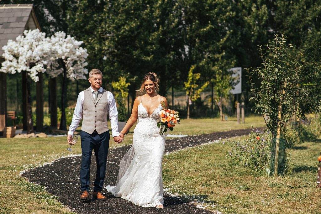 bride and groom walk in garden