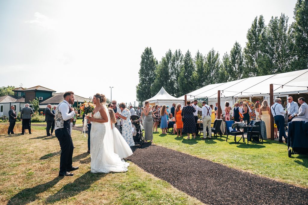 wedding guests on lawn by a marquee