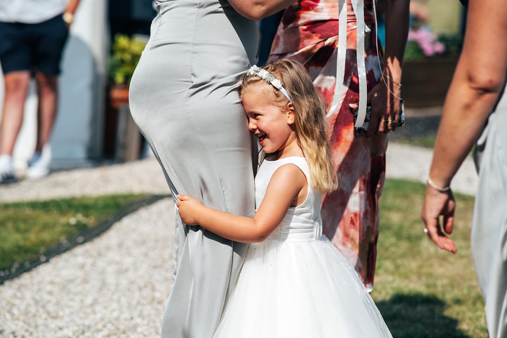 flower girl hugs mums legs