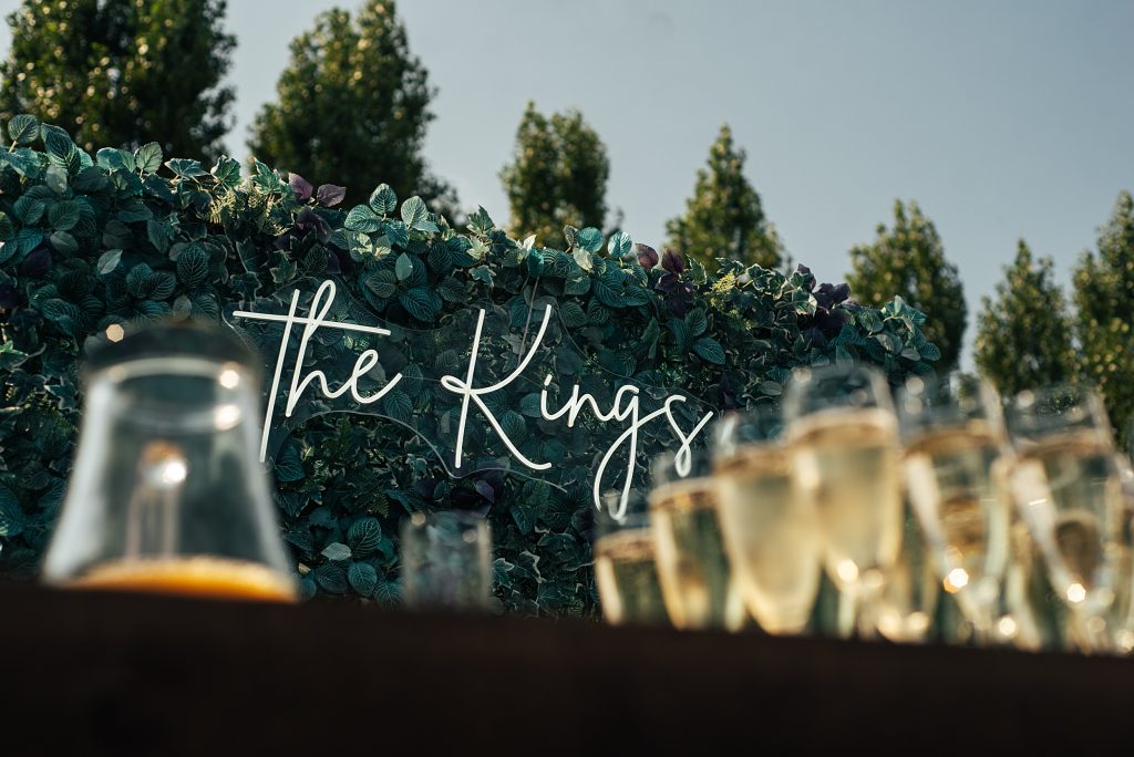 The Kings neon sign with champagne glasses in foreground