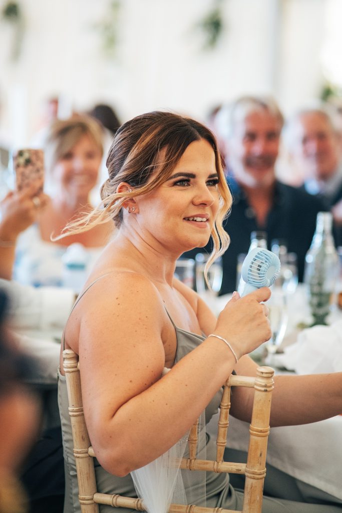 wedding guest fans herself during speeches