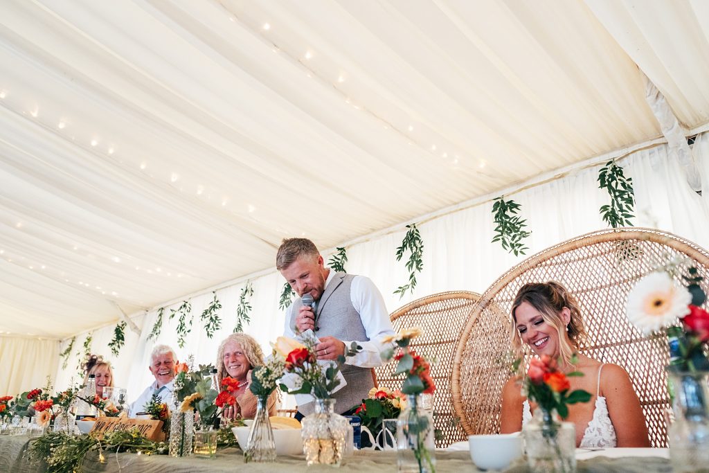 groom gives speech whilst top table laugh
