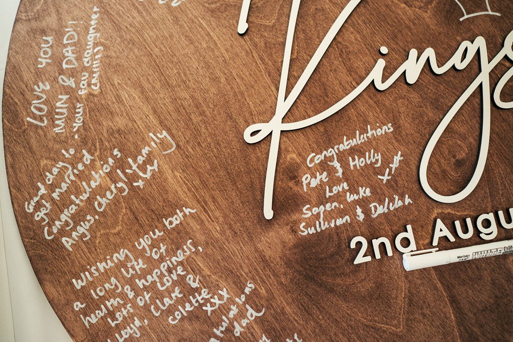 guests signatures on wooden board