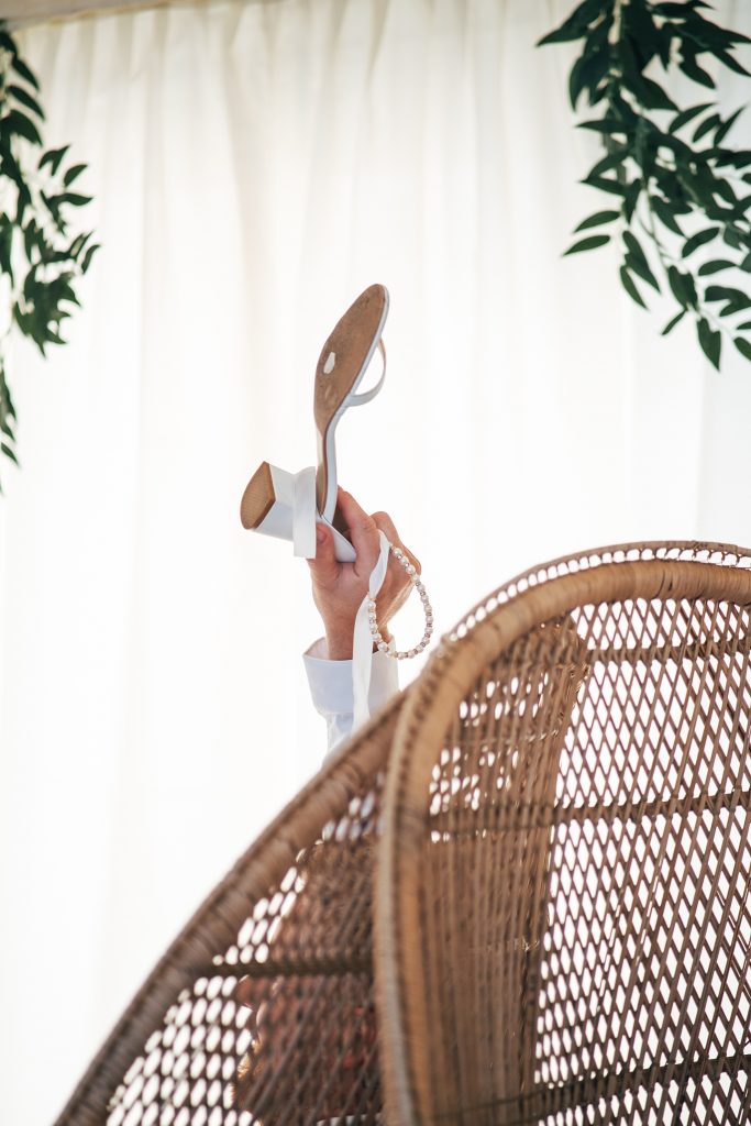 groom holds up bride shoe during game