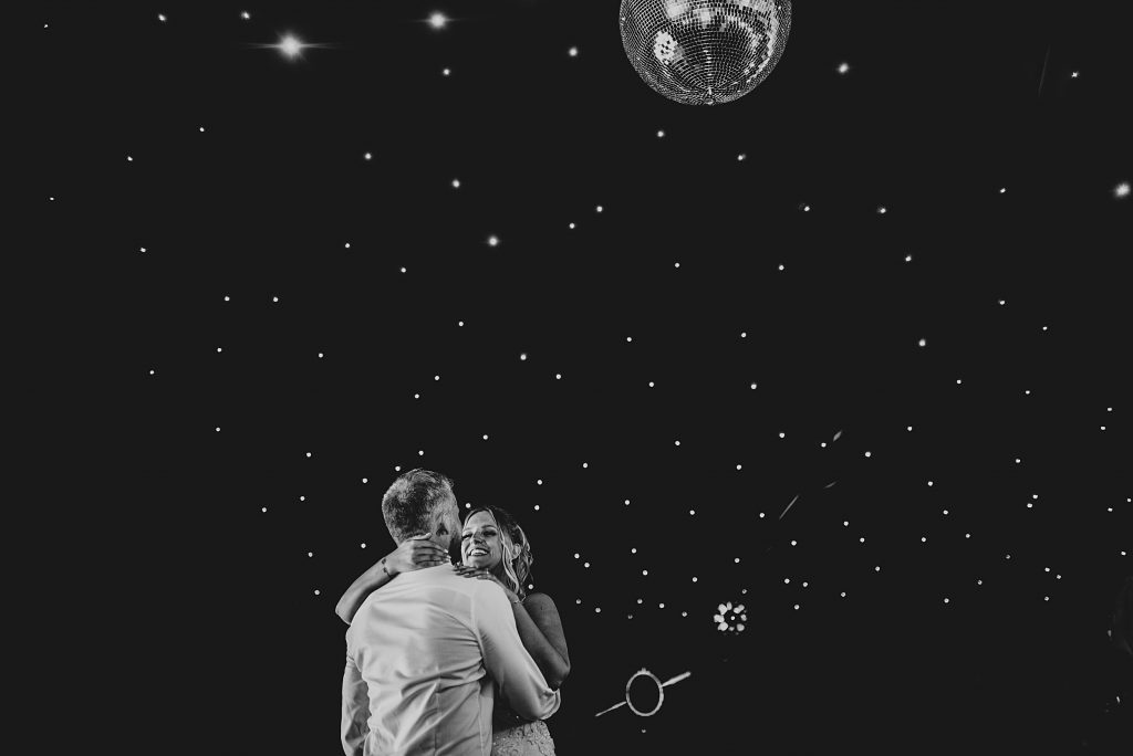 bride and groom first dance against starry lit black ceiling and disco ball
