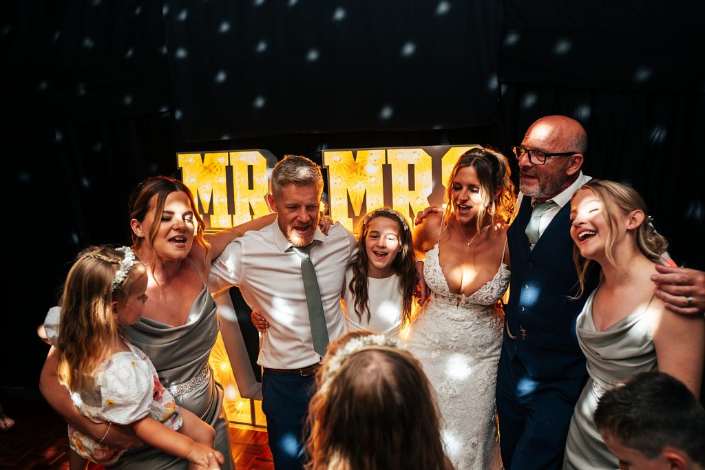 bride and groom with their family on dance floor