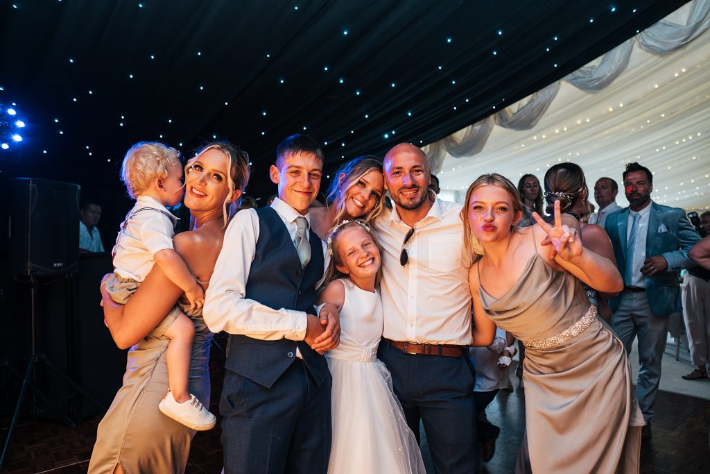 wedding guests pose on dance floor